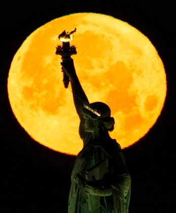 A rare Blue Moon, the second full moon to appear in the sky in a single month, sets behind the Statue of Liberty on Sunday, May 31, 2026 in New York City.  NYP20260531103 JOHNxANGELILLO