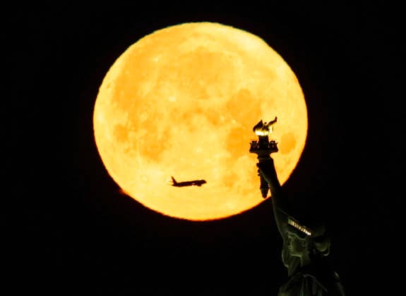 A rare Blue Moon, the second full moon to appear in the sky in a single month, sets behind the Statue of Liberty on Sunday, May 31, 2026 in New York City.  NYP20260531104 JOHNxANGELILLO