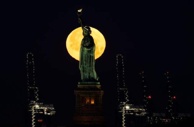 A rare Blue Moon, the second full moon to appear in the sky in a single month, sets behind the Statue of Liberty on Sunday, May 31, 2026 in New York City.  NYP20260531106 JOHNxANGELILLO