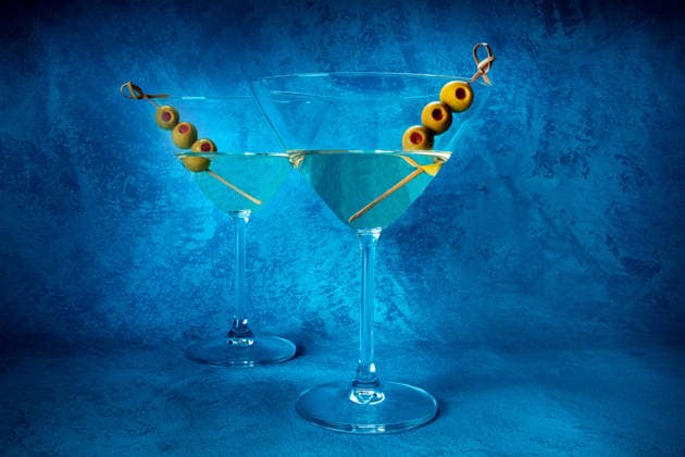 Martini. Zwei Gläser Dirty Martini mit Wermut und Oliven Martini. Two glasses of dirty martini cocktails with vermouth and olives, aperitif, on a blue background, side view (License=RF) Copyright: xZoonar.com IlyaxSolovyevx 25131986