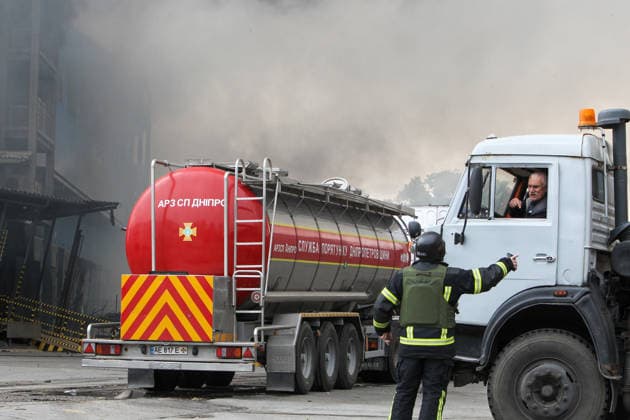 A rescuer talks to a driver at Nova Poshta Branch No. 1, destroyed by a Russian drone strike, Dnipro, Ukraine, on May 31, 2026. The strike destroyed the branch completely, with the building burning down. Cars parked nearby were also damaged. (Photo by Mykola Miakshykov Ukrinform) Russian drone attack destroys post branch in Dnipro  Copyright: xMykolaxMiakshykovx