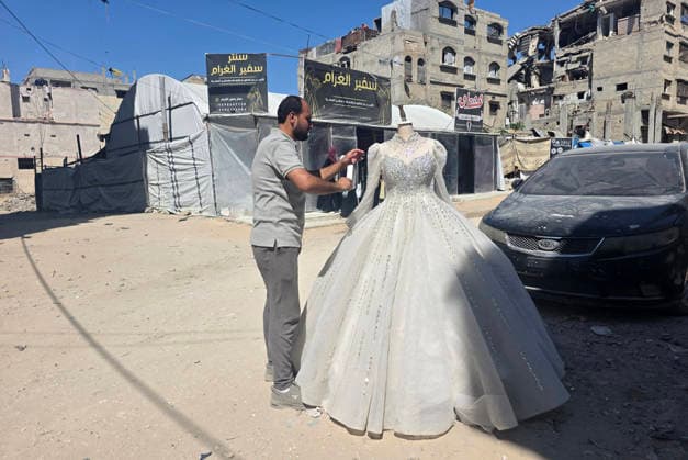 Customers browse wedding attire in Khan Younis despite wartime hardships Customers browse wedding dresses and suits inside a bridal shop in Khan Younis in the southern Gaza Strip on June 1, 2026, as Palestinians continue to uphold marriage traditions despite the ongoing war, widespread destruction, and difficult economic and humanitarian conditions. Shop owners say demand for wedding supplies remains present, though at a lower pace, as many families turn to less costly options amid declining incomes, rising prices, and shortages of goods linked to Israeli restrictions at border crossings. Photo by Tariq Mohammad APA Images Khan Yunis Gaza Strip Palestinian Territory 010626_Khan_Yunis_TM_00(9) Copyright: xapaimagesxTariqxMohammad xapaimagesx