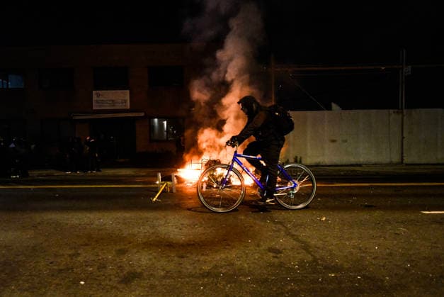 June 1, 2026, Newark, New Jersey, United States: A protester rides a bike past a fire set by protesters outside Delaney Hall during a protest. Protests continue to be held daily as detainees at Delaney Hall maintain a hunger and labor strike against current conditions at the facility. Newark United States - ZUMAs197 20260601_aaa_s197_241 Copyright: xMatthewxHatcherx