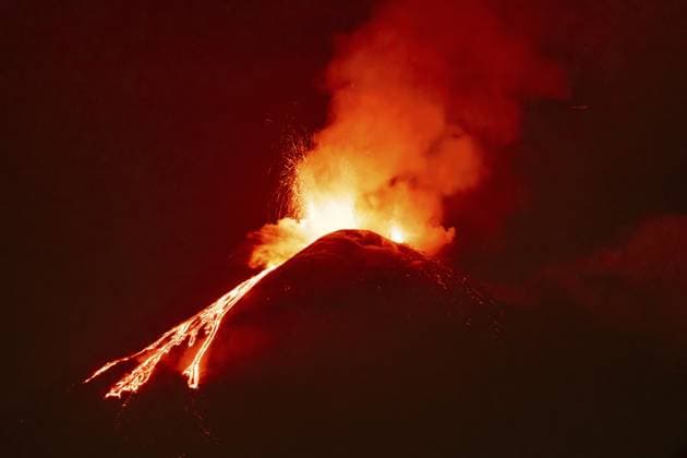 Der Ätna stößt nachts helle Lavaströme und eine dicke orangefarbene Rauchwolke aus, an der Krateröffnung sind eruptive Funken sichtbar Mount Etna expels bright lava flows and a thick orange smoke plume at night, with eruptive sparks visible around the crater opening Copyright: imageBROKER DetlefxVoigtxinfo ibxiqx17675689.jpg