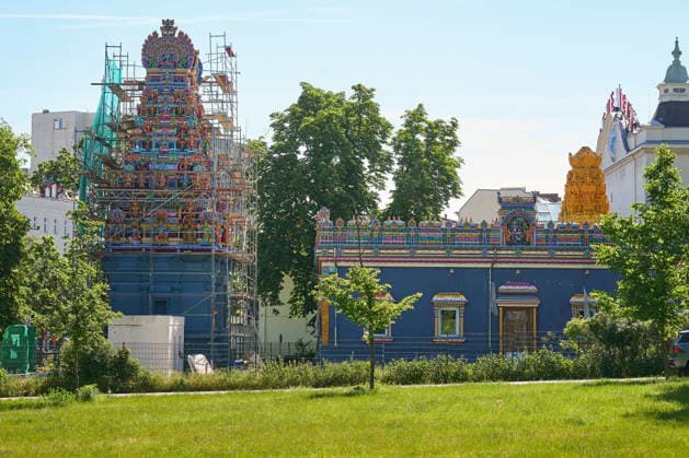 Sri Ganesha Hindu-Tempel in Berlin-Neukoelln (Foto vom 29.05.2026). Mehr als 20 Jahre nach den ersten Planungen wird jetzt in Berlin ein Hindu-Tempel eroeffnet. Dazu sind vom 3. bis 7. Juni mehrere Rituale geplant, erklaerte Vilwanathan Krishnamurthy vom Traegerverein Tempels in Berlin. Der Tempel steht am Beginn der Hasenheide, einer grossen Parkanlage in Berlin-Neukoelln. Die Fassade des rund 18 Meter hohen Turms zieren mehr als 200 farbenpraechtige Skulpturen. Dahinter schliessen sich weitere Gebaeudeteile an. Das rund 5.000 Quadratmeter umfassende Areal hat der Verein den Angaben zufolge vom Bezirk Neukoelln fuer 85 Jahre gepachtet. Die Baukosten bezifferte Krishnamurty auf rund 1,1 Millionen Euro. (Siehe epd-Bericht vom 02.06.2026) EDI Copyright: epd-bild ChristianxDitsch epd-Hindu-Tempel7-kopieren