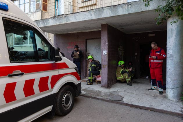 A paramedic and rescuers hide on the porch at an entrance to a nine-storey apartment block in the Podilskyi district during an air raid alert during a massive Russian missile and drone attack, Kyiv, Ukraine, on 2 June 2026. The overnight strike killed six people and injured 79, including three children, in the Ukrainian capital. In the Podilskyi district, residential buildings, a garage cooperative, a communal enterprise, and a four-storey educational institution sustained damage as a result of the attack. (Photo by Kyrylo Chubotin Ukrinform) Aftermath of Russian overnight attack in Kyiv’s Podilskyi district  Copyright: xKirillxChubotinx