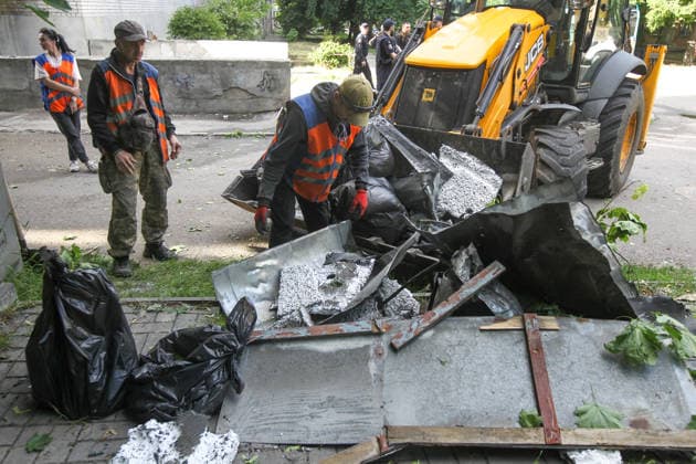 A utility worker in an orange vest puts the fragments of the roof, bent metal sheets, and remnants of insulation into an excavator’s bucket near a nine-storey apartment block hit by a Russian drone in Dnipro, Ukraine, on 2 June 2026. During the day, Russian occupation forces carried out another strike on the city, targeting a block of flats with a jet drone. As a result of the direct hit, one apartment burned to the ground, and neighbouring flats also sustained significant damage. Two children were injured and taken to the hospital with moderate injuries. (Photo by Mykola Miakshykov Ukrinform) Russian drone strikes block of flats in Dnipro  Copyright: xMykolaxMiakshykovx