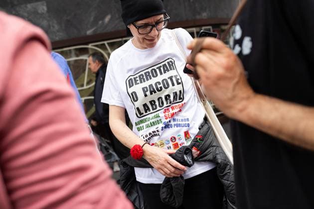 June 3, 2026, Porto, Portugal: A protester wears a T?shirt with slogans opposing the labour package during the national general strike at Praca da Batalha. Demonstrators gathered at Praca da Batalha and Avenida dos Aliados for a national general strike. Union groups, workers and supporters marched with banners, flags and handwritten signs criticizing the government™s proposed labour reforms and calling for improved working conditions, higher wages and stronger public services. The protest featured megaphones, flares and visual messages reflecting broad mobilization across the city. Porto Portugal - ZUMAs197 20260603_aaa_s197_026 Copyright: xDiogoxBaptistax