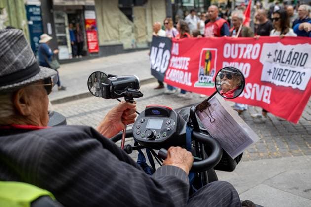 June 3, 2026, Porto, Portugal: An older man appears reflected in a mobility?scooter mirror while protesters march during the national general strike. Demonstrators gathered at Praca da Batalha and Avenida dos Aliados for a national general strike. Union groups, workers and supporters marched with banners, flags and handwritten signs criticizing the government™s proposed labour reforms and calling for improved working conditions, higher wages and stronger public services. The protest featured megaphones, flares and visual messages reflecting broad mobilization across the city. Porto Portugal  - ZUMAs197 20260603_aaa_s197_027 Copyright: xDiogoxBaptistax