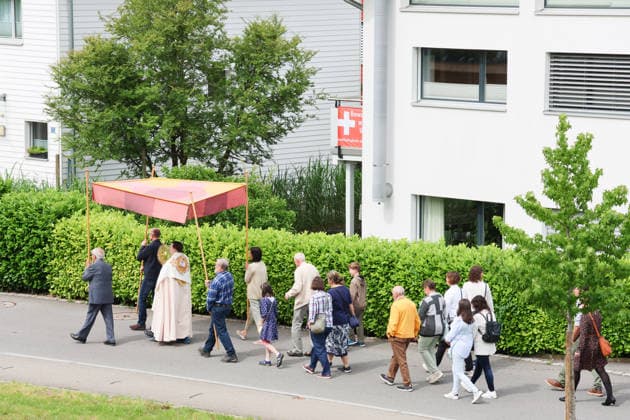 04.06.2026 Sschweiz. Gesetzlicher Feiertag der Katholiken. Bild, Fronleichnam Umzug mit Blasmusik in Kerns Kanton Obwalden.Am Haus ist ein Plakat Keine 10 Millionen Schweiz .Nachhaltigkeits-Initiative *** 04 06 2026 Switzerland Legal holiday for Catholics Picture, Corpus Christi Parade with brass band music in Kerns Canton Obwalden There is a poster on the house No 10 million Switzerland Sustainability Initiative 