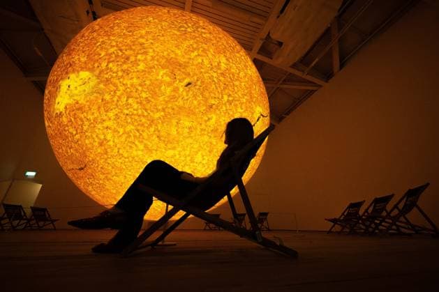 Preview of The Sun and The Moon: Art Inspired by the Celestial exhibition in London LONDON, UNITED KINGDOM - JUNE 4: A woman observes Helios, a large-scale sun installation by British artist Luke Jerram, during the press preview of The Sun and The Moon: Art Inspired by the Celestial exhibition at the Saatchi Gallery in London, United Kingdom on June 4, 2026. Rasid Necati Aslim Anadolu London United Kingdom. Editorial use only. Please get in touch for any other usage.  Copyright: x2026xAnadoluxRasidxNecatixAslimx