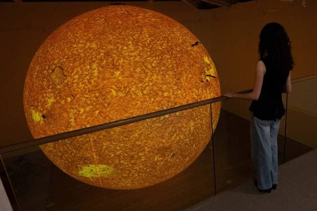 Preview of The Sun and The Moon: Art Inspired by the Celestial exhibition in London LONDON, UNITED KINGDOM - JUNE 4: A woman observes Helios, a large-scale sun installation by British artist Luke Jerram, during the press preview of The Sun and The Moon: Art Inspired by the Celestial exhibition at the Saatchi Gallery in London, United Kingdom on June 4, 2026. Rasid Necati Aslim Anadolu London United Kingdom. Editorial use only. Please get in touch for any other usage.  Copyright: x2026xAnadoluxRasidxNecatixAslimx