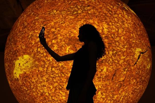 Preview of The Sun and The Moon: Art Inspired by the Celestial exhibition in London LONDON, UNITED KINGDOM - JUNE 4: A woman takes a selfie in front of Helios, a large-scale sun installation by British artist Luke Jerram, during the press preview of The Sun and The Moon: Art Inspired by the Celestial exhibition at the Saatchi Gallery in London, United Kingdom on June 4, 2026. Rasid Necati Aslim Anadolu London United Kingdom. Editorial use only. Please get in touch for any other usage.  Copyright: x2026xAnadoluxRasidxNecatixAslimx