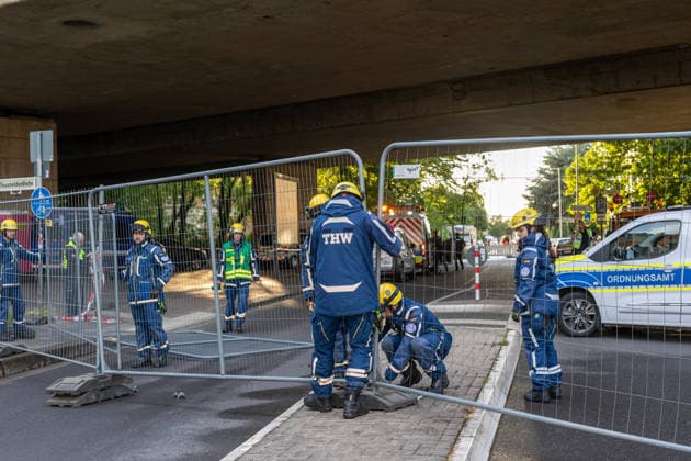 Bonn, THW-Kräfte errichten Bauzäune und sperren die Römerstraße unterhalb der Nordbrücke. Bonn, 04.06.2026: Einsatzkräfte des Technischen Hilfswerks (THW) errichten Bauzäune und sperren die Römerstraße im Bereich unterhalb der Nordbrücke für Fußgänger, Autos und Busse. Die Sperrung besteht seit etwa 19:30 Uhr und steht im Zusammenhang mit der Einsturzgefahr der Bonner Nordbrücke (Friedrich-Ebert-Brücke). Die Autobahnbrücke der A565 wurde bereits am 3. Juni 2026 nach der Feststellung struktureller Schäden am Tragwerk vollständig für den Verkehr gesperrt. Die aktuellen Maßnahmen dienen der Sicherung des Bereichs unterhalb des Bauwerks. Bonn castell Nordrhein-Westfalen Deutschland *** Bonn, THW forces erect construction fen