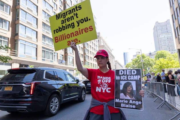 June 4, 2026, New York, New York, USA: Demonstrators join Rise and Resist s weekly vigil for those impacted by the Trump administration s immigrant detention and mass deportation policies outside the immigration courts, Department of Homeland Security and U.S. Immigration and Customs Enforcement offices at 26 Federal Plaza in Lower Manhattan. A participant wears a shirt that reads HANDS OFF NYC and holds signs that read Migrants aren t robbing you. Billionaires are. DIED in ICE CAMP Marie Ange Blaise. Protesters denounce the newest Justice Department policies of moving up the dates of immigrants hearings and scheduling mega masters, calendar hearings including 100 or more people at a time. New York USA - ZUMAr174 20260604_znp_r174_019 Copyright: xGinaxMxRandazzox