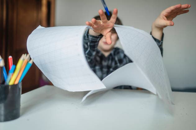 Frustrated schoolboy throwing paper while studying at home model released, Symbolfoto property released, ANAF05806