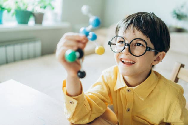 Smiling child holding a chemistry molecule model indoors model released, Symbolfoto property released, ANAF05823
