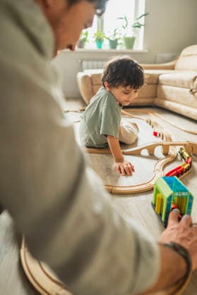 Father and son playing with a wooden toy train at home model released, Symbolfoto property released, ANAF05835