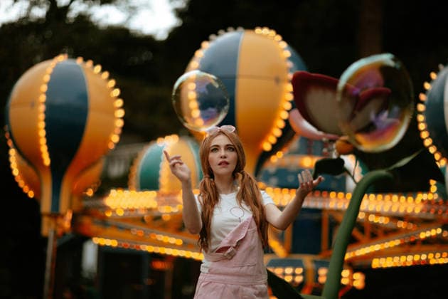 Woman playing with giant bubble at illuminated amusement park model released, Symbolfoto, GMLF01620