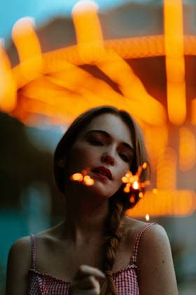 Holding a glowing sparkler at an amusement park at night model released, Symbolfoto, GMLF01629
