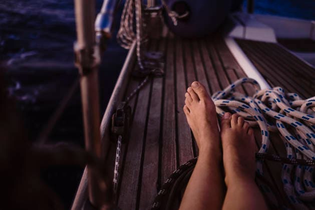 Barefoot resting on the wooden deck of a sailing boat model released, Symbolfoto, GMLF01647