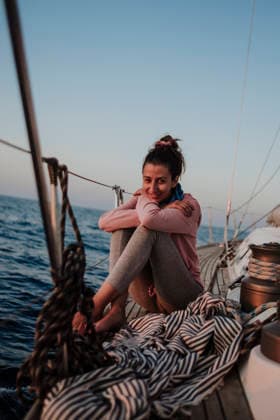 Smiling woman relaxing on a sailing boat at sunset model released, Symbolfoto, GMLF01650