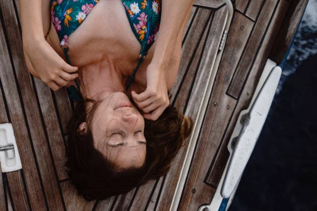 Woman relaxing on the wooden deck of a sailboat in summer model released, Symbolfoto, GMLF01652