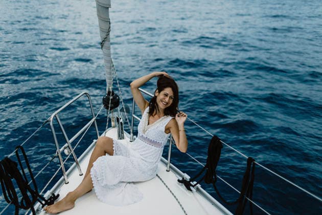Smiling woman in white dress relaxing on sailboat in ocean model released, Symbolfoto, GMLF01686