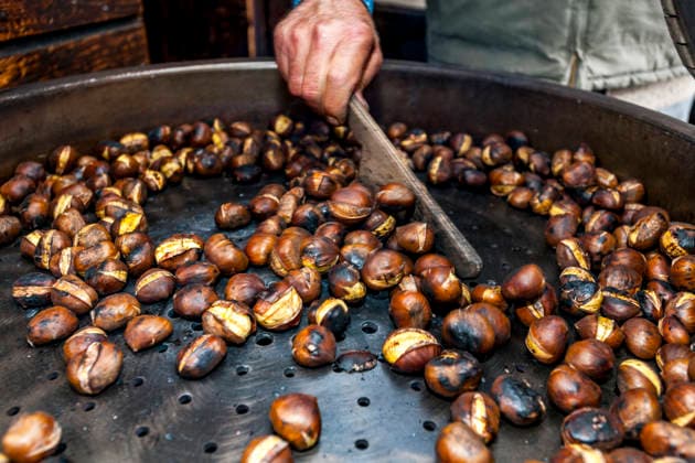 Roasting chestnut at a street market in Bellinzona Ticino, Lugano Tessin Schweiz Lugano EGBF01841