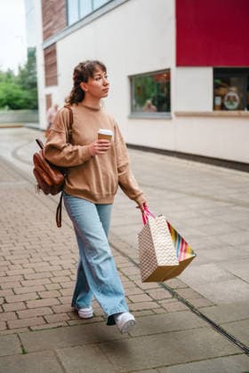 Shopper walking with retail bag and coffee cup on modern city street model released, Symbolfoto, IGEF00928