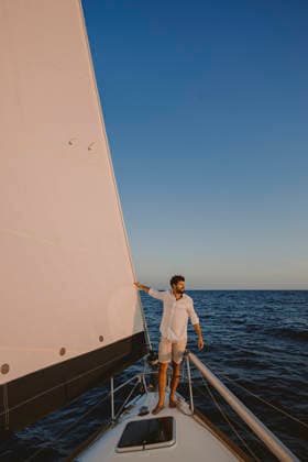 Man standing on sailboat deck enjoying summer travel and freedom model released, Symbolfoto property released, GMLF01879