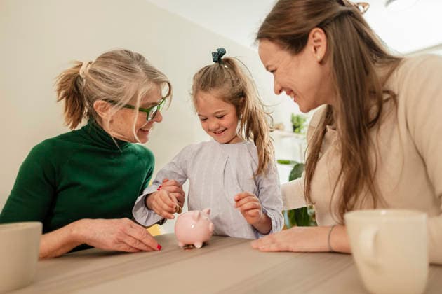 Smiling mother and grandmother teach daughter saving money indoors model released, Symbolfoto property released, JCCMF15274