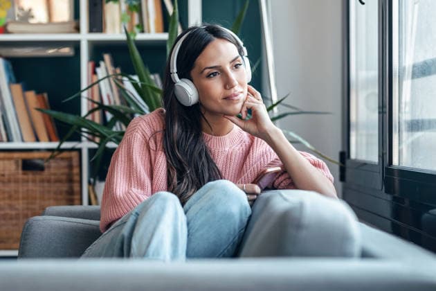 Listening to music and relaxing on a cozy sofa indoors model released, Symbolfoto property released, JSRF04444
