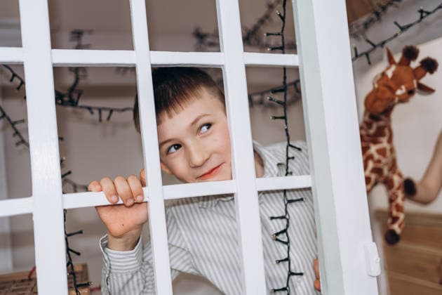 Curious person looking through white wooden gate indoors model released, Symbolfoto property released, KANF00185