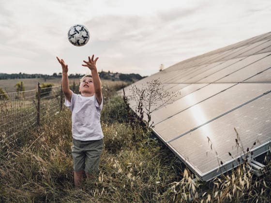 Child playing with soccer ball near solar panel in Tuscany meadow model released, Symbolfoto, MFF10105