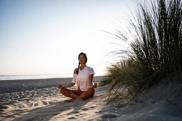 Woman practicing yoga and meditating on a sandy summer beach model released, Symbolfoto, UUF36836