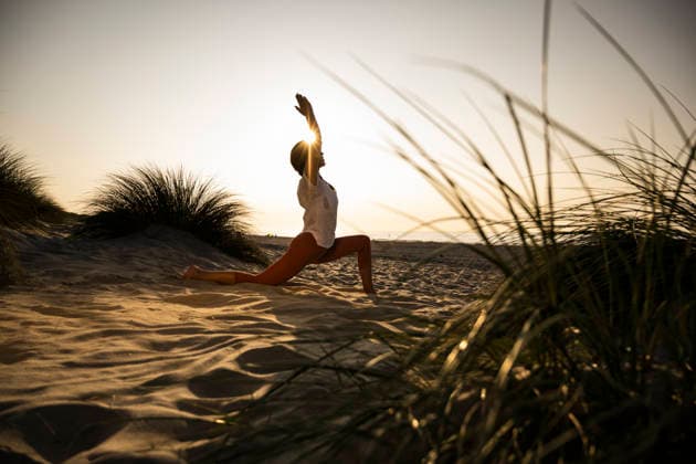 Woman practicing yoga on a sandy beach at sunset model released, Symbolfoto, UUF36838