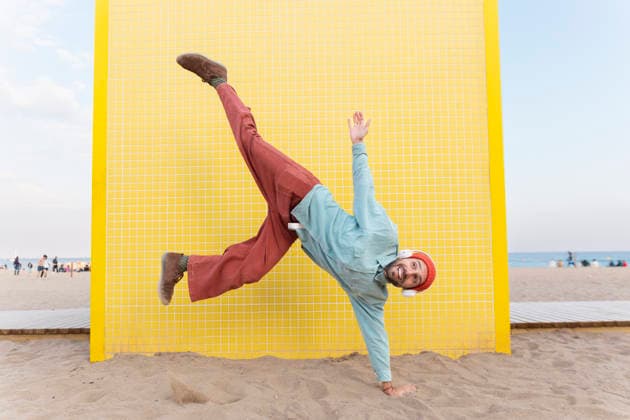 Energetic superhero flying in handstand pose on Barcelona beach model released, Symbolfoto, YPF00275