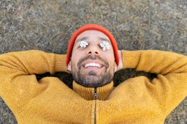 Smiling outdoors with white flowers covering eyes in spring model released, Symbolfoto, YPF00284
