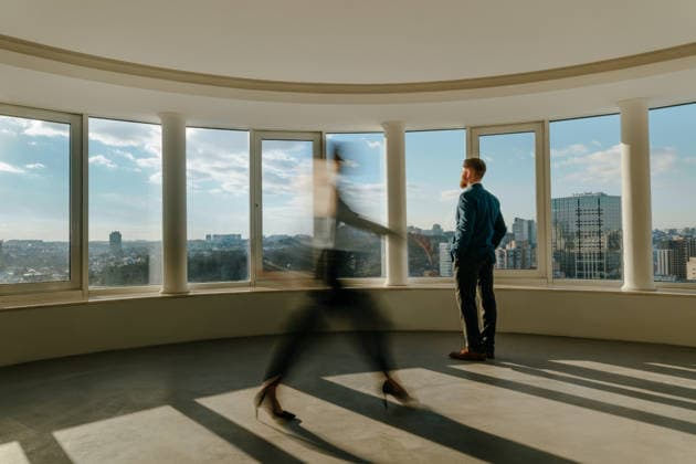 Blurred moving coworker and standing person looking out office window model released, Symbolfoto property released, YTF04817