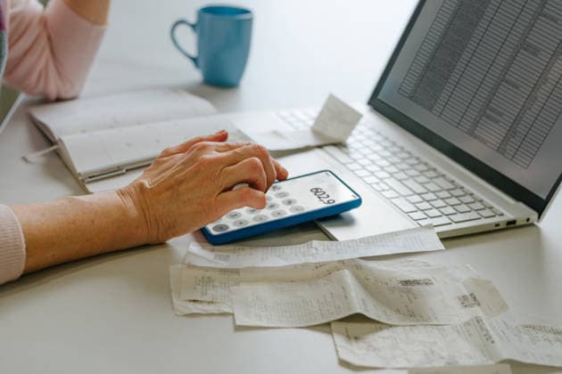 Woman calculating home budget and taxes using smartphone and laptop model released, Symbolfoto property released, YTF04874