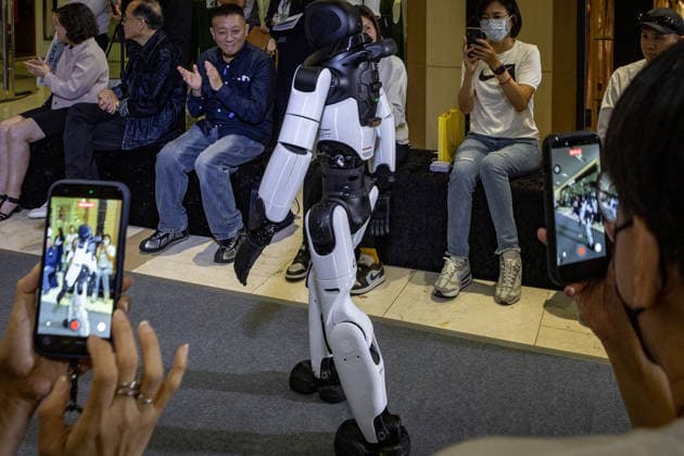 June 6, 2026, Kaohsiung City, Kaohsiung City, Taiwan: A bipedal humanoid robot walks down the runway at the 2026 EDA Fashion Show under the theme FASHION GENESIS, marking Taiwan s first-ever robotic fashion runway event, while attendees hold up smartphones to record the performance at E-DA Outlet Mall in Kaohsiung on June 6, 2026. Kaohsiung City Taiwan - ZUMAh198 20260606_zip_h198_003 Copyright: xCheng-ChiaxHuangx