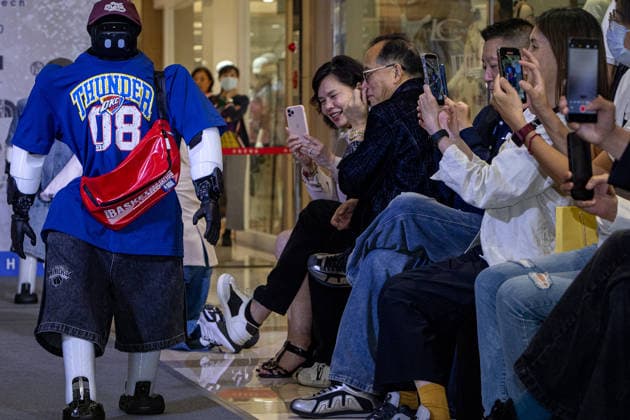 June 6, 2026, Kaohsiung City, Kaohsiung City, Taiwan: A bipedal humanoid robot walks down the runway at the 2026 EDA Fashion Show under the theme FASHION GENESIS, marking Taiwan s first-ever robotic fashion runway event, while attendees hold up smartphones to record the performance at E-DA Outlet Mall in Kaohsiung on June 6, 2026. Kaohsiung City Taiwan - ZUMAh198 20260606_zip_h198_008 Copyright: xCheng-ChiaxHuangx