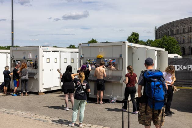 Musikfestival Rock im Park 2026, Nürnberg, 06.06.2026 Festivalbesucher nutzen mobile Sanitärcontainer mit Waschgelegenheiten auf dem Gelände des Rock im Park. Im Hintergrund ist die Kongresshalle des ehemaligen Reichsparteitagsgeländes sichtbar. Nürnberg Bayern Deutschland *** Rock im Park 2026 music festival, Nuremberg, 06 06 2026 Festival visitors use mobile sanitary containers with washing facilities on the grounds of Rock im Park The congress hall of the former Nazi Party Rally Grounds is visible in the background Nuremberg Bavaria Germany 20260606-286A8114-M4000