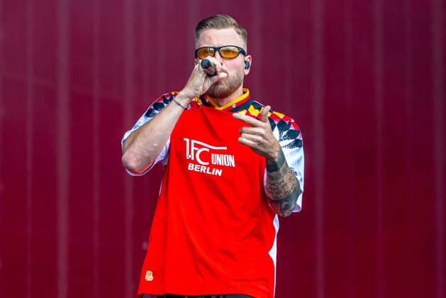 Musikfestival Rock im Park 2026 - FINCH, Nürnberg, 06.06.2026 Rapper Finch mit Mikrofon auf der Buehne, gekleidet in einem Trikot des 1. FC Union Berlin. Der deutsche Musiker ist bekannt fuer seinen Mix aus 80er-Jahre-Aesthetik, Electro-Beats und Rap. Nürnberg Bayern Deutschland *** Music festival Rock im Park 2026 FINCH, Nuremberg, 06 06 2026 Rapper Finch with microphone on stage, dressed in a jersey of 1 FC Union Berlin The German musician is known for his mix of 80s aesthetics, electro beats and rap Nuremberg Bavaria Germany 20260606-1V9A0189-M4000