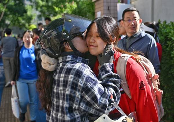 (260607) -- BEIJING, June 7, 2026 -- A parent kisses her daughter before the exam at a national college entrance examination site in Beijing, capital of China, June 7, 2026. This year s national college entrance exam, also known as the gaokao, kicked off Sunday nationwide. ) FOCUS 2026 college entrance exam kicks off nationwide LixXin 