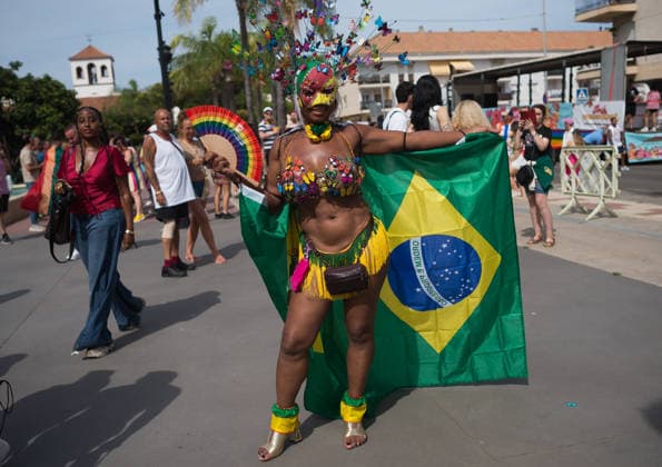 June 6, 2026, Malaga, Spain: A woman is seen holding a colorful fan as he poses for a photo with the brazilian flag during a demonstration in support of the rights of LGTBIQ+ people, as part of the LGTBIQ+ Pride celebrations. The LGTBIQ+ Pride of Torremolinos is internationally known as a meeting point for LGTBIQ+ people in a colourful and festive atmosphere, where thousands of people celebrate the fight of the LGTBIQ+ movement for equality and respect. Malaga Spain - ZUMAs197 20260606_aaa_s197_354 Copyright: xJesusxMeridax