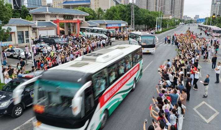 (260607) -- BEIJING, June 7, 2026 -- Teachers and parents see off buses carrying students to the national college entrance examination sites in Xiangyang, central China s Hubei Province, June 7, 2026. This year s national college entrance exam, also known as the gaokao, kicked off Sunday nationwide. (Photo by Xinhua) CHINA-COLLEGE ENTRANCE EXAM (CN) WangxHu 