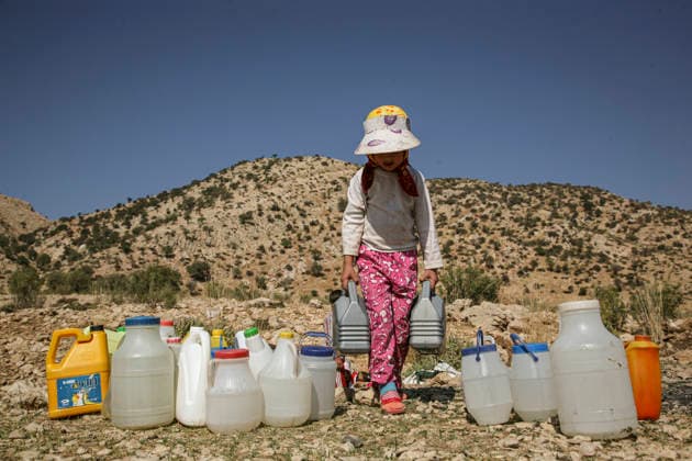 Iran Yasuj Lur Nomads A young Lur girl carries water containers near Yasuj, Kohgiluyeh and Boyer-Ahmad province, Iran on April 24, 2010. Water shortages threaten the livelihoods of Lur nomadic communities who depend on seasonal migration and access to natural water sources. Yasuj Kohgiluyeh Boyer-Ahmad Province Iran Copyright: xEshaaqxAqaeix