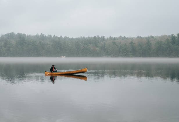 Man paddling a canoe on a still foggy lake Buck Lake, Ontario, Canada CR_DOHO260604G-2040774-01 ,model released, Symbolfoto